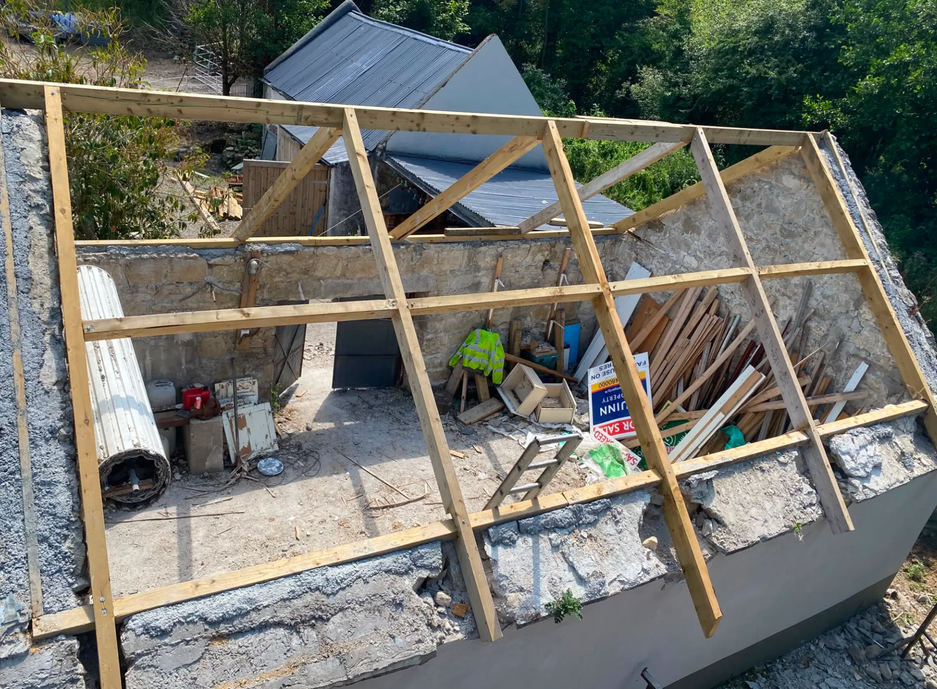 New timber roof structure being installed on a stone agricultural building